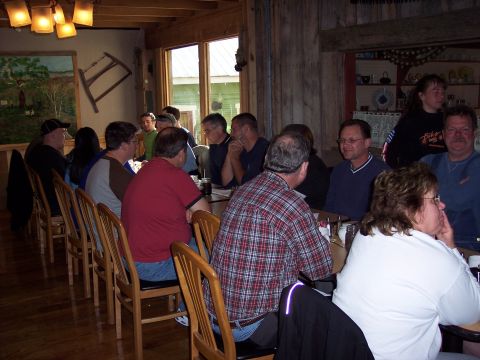 1985 Ford LTD Crown Victoria - Diners are seated at tables in a rustic restaurant setting with wooden paneling and overhead lighting.
