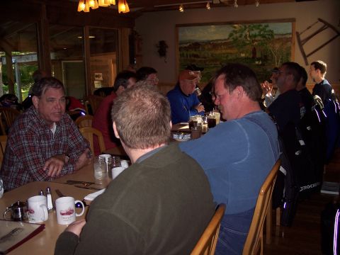 1985 Ford LTD Crown Victoria - Men gather for a meal at a restaurant, with a landscape painting on the wall behind them.