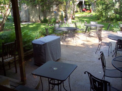 1985 Ford LTD Crown Victoria - A backyard patio scene with various outdoor furniture and a covered grill.