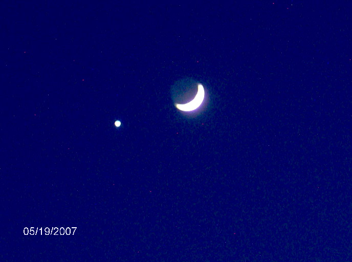 Crescent moon and a bright planet in a dark blue sky. Date 05/19/2007