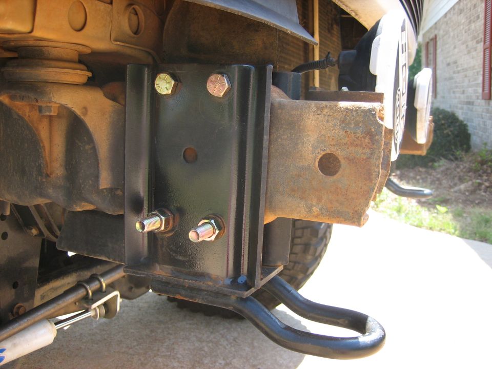 Black welded tow hitch and bracket mounted under a vehicle rear