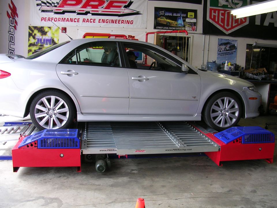 Silver Mazda 6 sedan on a PRE Racing chassis dyno inside a performance shop
