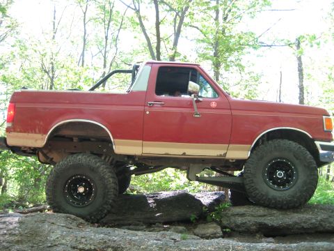 1990 Ford Bronco - This lifted Ford Bronco navigates a rocky trail, its off-road capabilities.