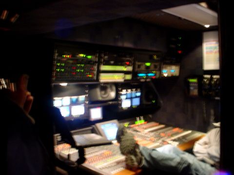 2000 Ford Taurus - Inside a video production control room, showing various monitors and a large audio mixing console.