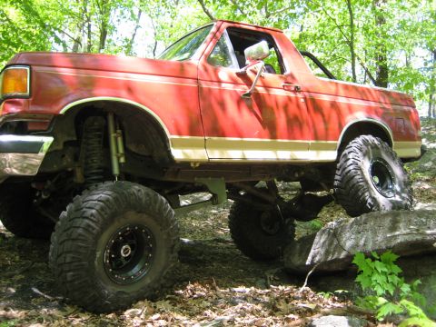 1990 Ford Bronco - This modified Ford Bronco navigates a rocky obstacle course in a wooded area.