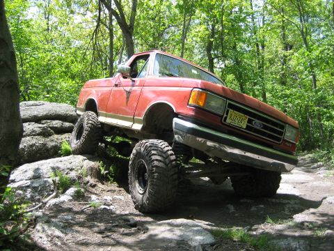 1990 Ford Bronco - This lifted Ford Bronco is shown off-roading on a rocky trail.