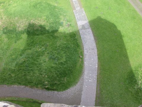 1995 Ford Bronco - The shadow of a building falls across a grassy landscape with a winding stone path.