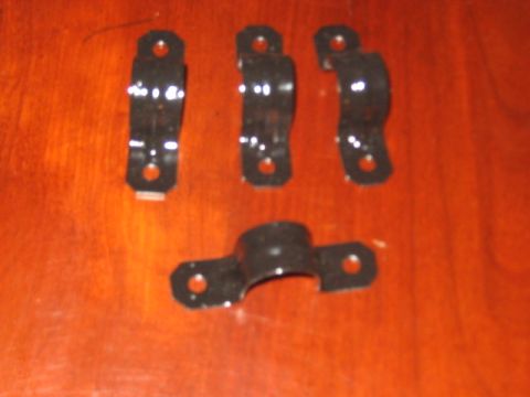 1991 Ford Bronco - Four black metal hose clamps are arranged on a wooden surface. These appear to be automotive parts.