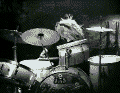 1987 Suzuki Samurai - A drummer plays a drum kit, captured in a black and white photograph.