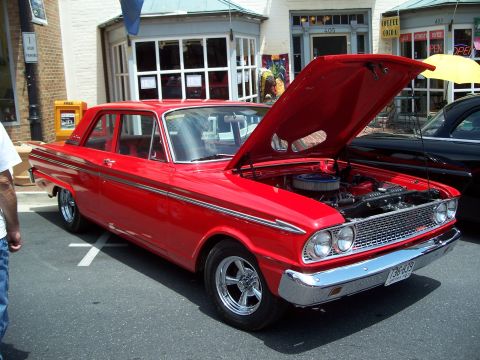 1971 Ford Ranchero - A classic red sedan is parked on a street with its hood open, revealing the engine compartment.