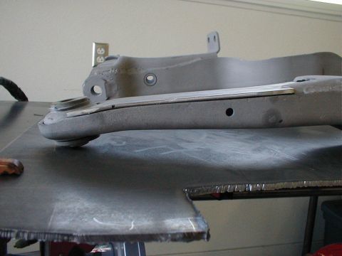 1996 Ford Bronco - A gray suspension component, possibly a control arm, is shown with a metal shim inserted.