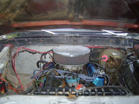 1979 Ford Bronco - The engine compartment of a vehicle is shown with various engine components and wiring.