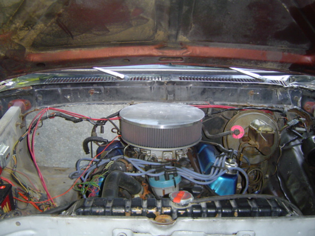 Engine bay with V8 engine, air cleaner, distributor, and wiring visible