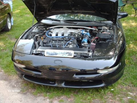 1995 Ford Probe - A black 1995 Ford Probe is displayed with its hood open, revealing the engine bay and modifications.