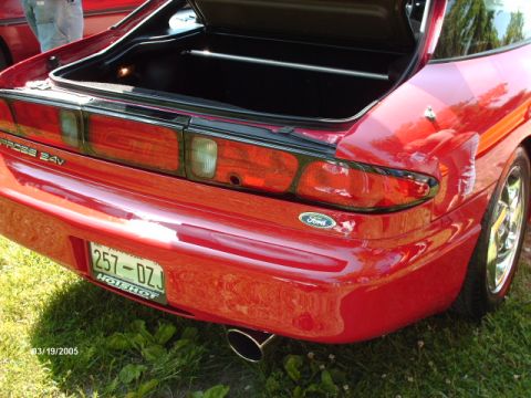 1995 Ford Probe - The rear of a red 1995 Ford Probe is shown with the trunk open, revealing the taillights and a license plate.