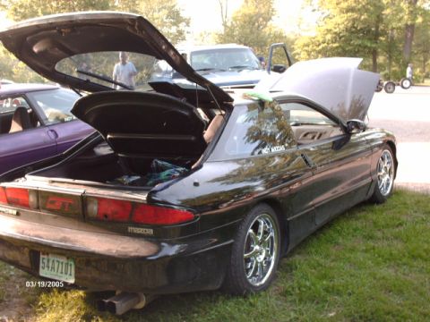 1995 Ford Probe - 1995 Mazda Probe GT with open trunk and hood, parked on grass with other vehicles nearby.