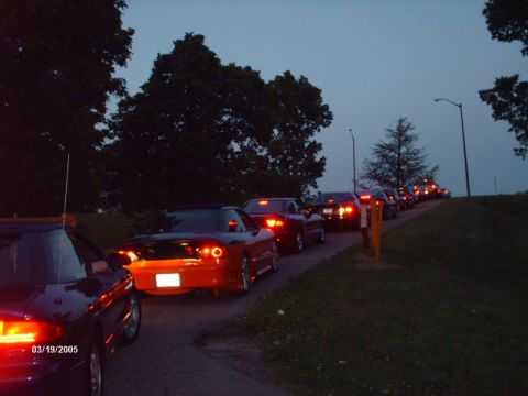 1995 Ford Probe - A line of cars are seen on a road at dusk, with taillights illuminated.