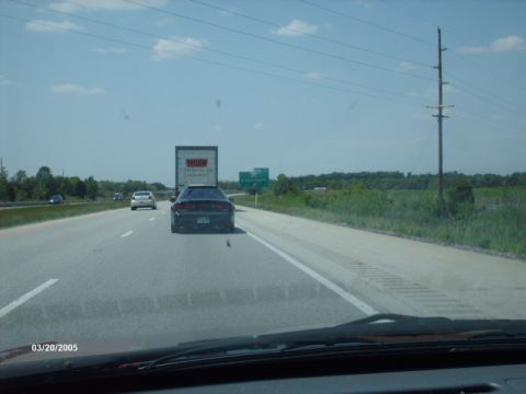 1995 Ford Probe - A black 1995 Ford Probe is seen from behind while driving on a highway.