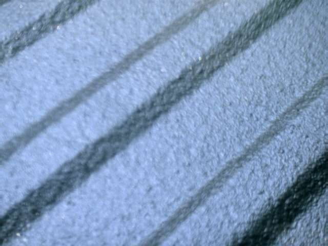 Close-up of a tire tread pattern with diagonal grooves. Supermotors.net logo visible