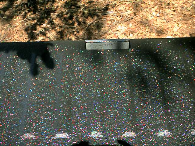 Sparkling black paint on a vehicle part with a chrome strip