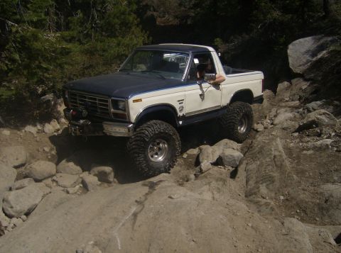 1986 Ford Bronco - This modified Ford Bronco is tackling a challenging rocky terrain, far from a registry office.