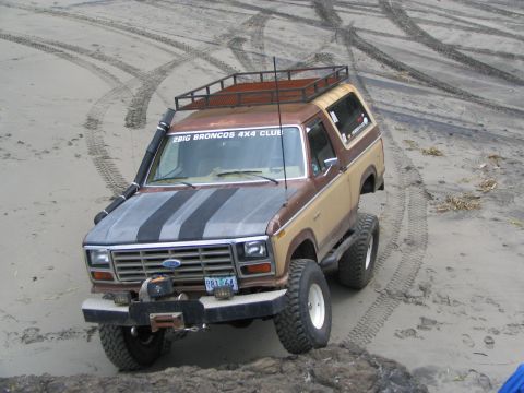 1983 Ford Bronco - This modified Ford Bronco is equipped with a snorkel and roof rack, ready for off-road adventures on the sandy terrain.