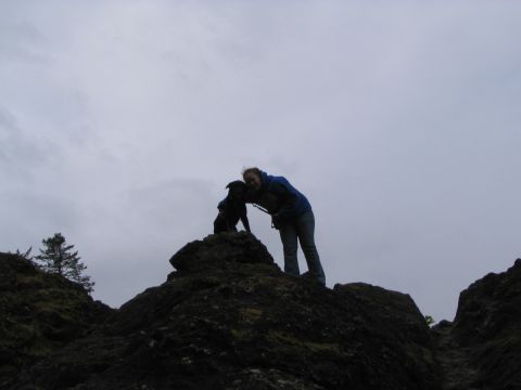 1983 Ford Bronco - A person and their dog enjoy a moment together on a rocky landscape, with a cloudy sky overhead.