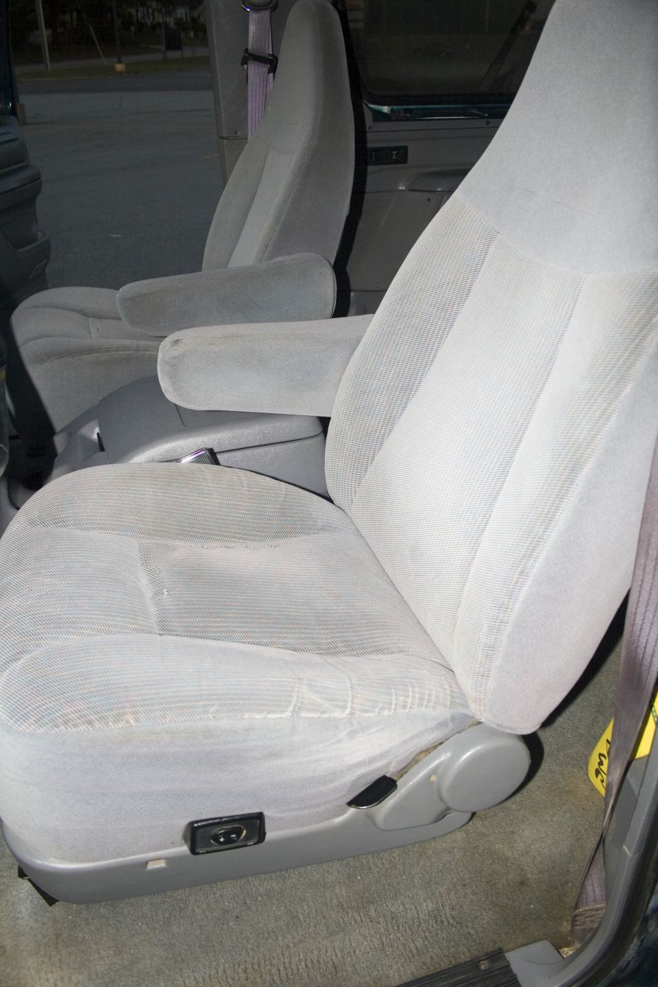 Gray cloth front bucket seats with armrests inside a vehicle