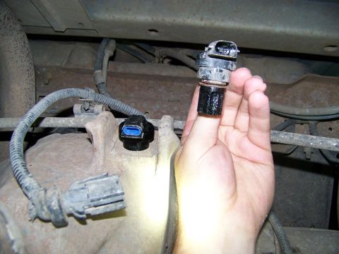 1995 Ford Bronco - A person is holding a vehicle speed sensor, with other parts of the undercarriage visible.