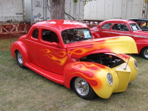 1989 Ford Mustang - This custom hot rod coupe features a flame paint job and has its hood open, revealing the engine bay.
