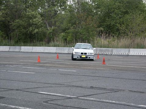 2001 Mercury Grand Marquis - A white BMW E36 navigates a course marked by orange traffic cones on a paved surface.