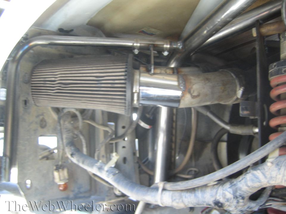 Cone air filter, chrome intake and red coil-over in engine bay