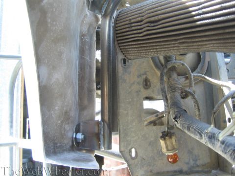 1990 Ford Bronco - Detail of a vehicle's front frame bracket, hardware, finned cooler and routed wiring during fabrication.