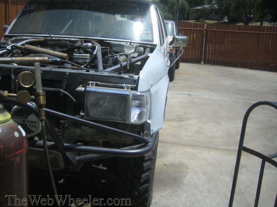 Front quarter of a project truck with open hood and tube bumper