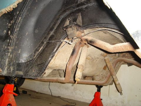 1962 Ford Thunderbird - Underside view of a vehicle's rear suspension and exhaust system, showing signs of rust and wear.