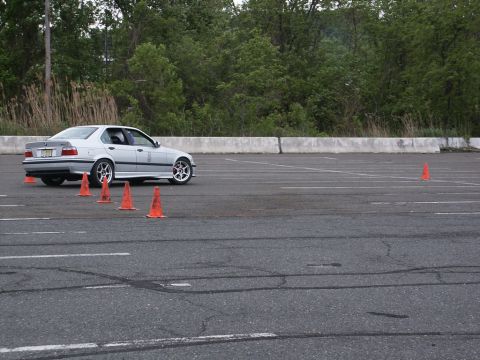 2001 Mercury Grand Marquis - Silver sedan with aftermarket wheels on an asphalt course with orange cones.