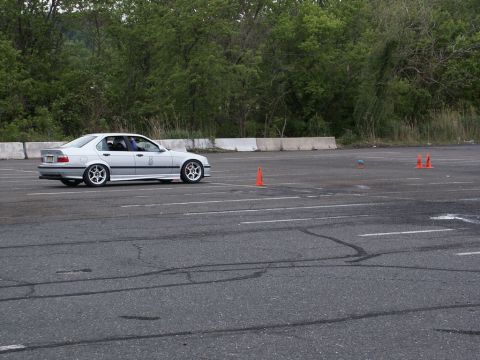 2001 Mercury Grand Marquis - A silver BMW E36 sedan navigates a course marked by orange cones on a paved track.
