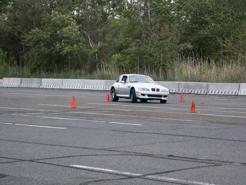 2001 Mercury Grand Marquis - A silver BMW Z3 coupe is seen on a race track, maneuvering around orange cones during an event.