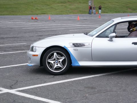 2001 Mercury Grand Marquis - A silver BMW Z3 M Coupe is seen on a track with orange cones in the background.