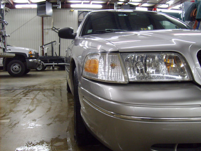 2004 Ford Crown Victoria front corner, parked indoors next to a tow truck