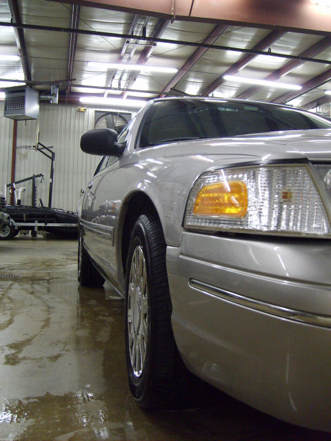 2004 Ford Crown Victoria - A silver 2004 Ford Crown Victoria is parked indoors on a wet floor.
