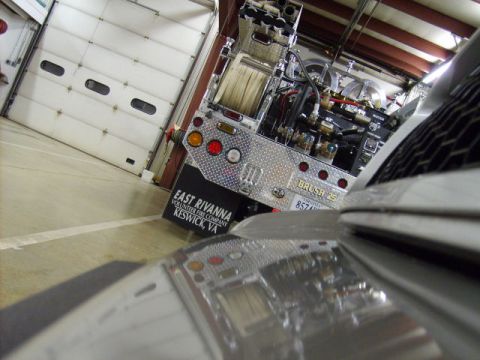 2004 Ford Crown Victoria - A fire truck with 'Brush 25' and a license plate is parked inside a garage.