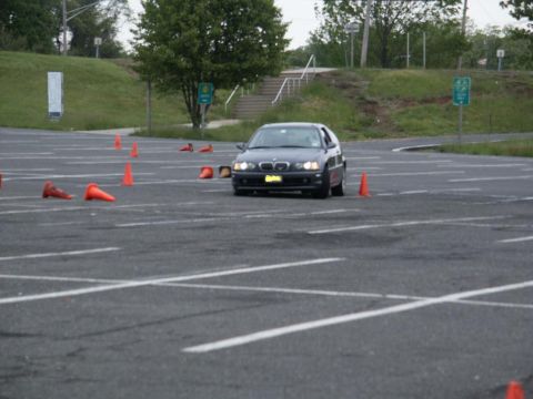 2001 Mercury Grand Marquis - A dark blue BMW 3 Series E46 sedan is seen on a course marked by orange cones.