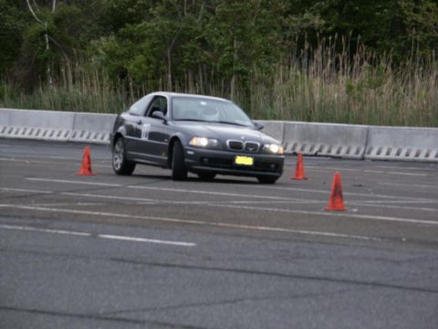 2001 Mercury Grand Marquis - A BMW 3 Series coupe is shown on a race track during an event with orange cones marking the course.