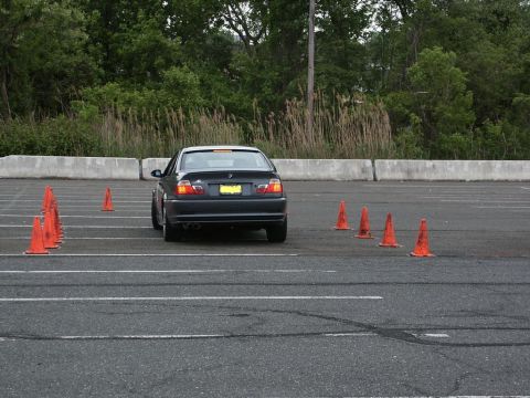 2001 Mercury Grand Marquis - BMW E46 sedan maneuvers through an autocross course with orange cones marking the path.