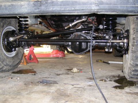 1993 Ford Bronco - Close-up view of a vehicle's undercarriage, focusing on the suspension and drivetrain components.