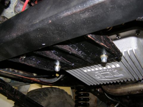 1993 Ford Bronco - Vehicle underbody detail, focusing on the transmission pan and suspension components.