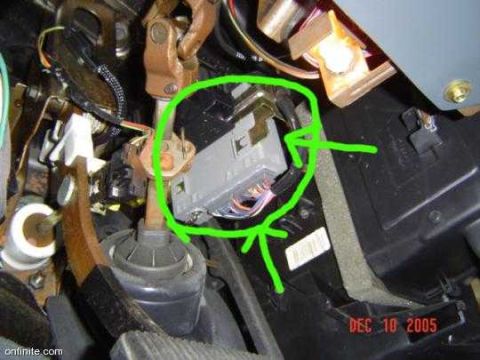 1997 Ford Taurus - Close-up under a vehicle's dashboard showing a black electronic module or connector circled in green marker, surrounded by wiring harnesses…