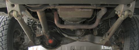 1984 Ford Bronco - Underside view of vehicle suspension components, including exhaust and differential. Watermark present.