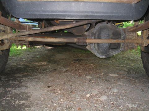 1979 Ford Bronco - Underside view of a vehicle's rear solid axle and differential, showing a rusty axle housing, leaf spring, and driveshaft, photographed fro…